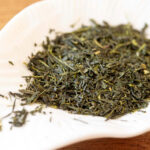 Sencha green tea leaves in a white dish